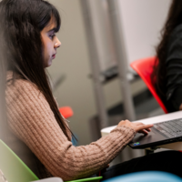 Student in a classroom working on a laptop
