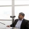 Dr. Dasgupta sitting behind a microphone in an open space in USG's building III